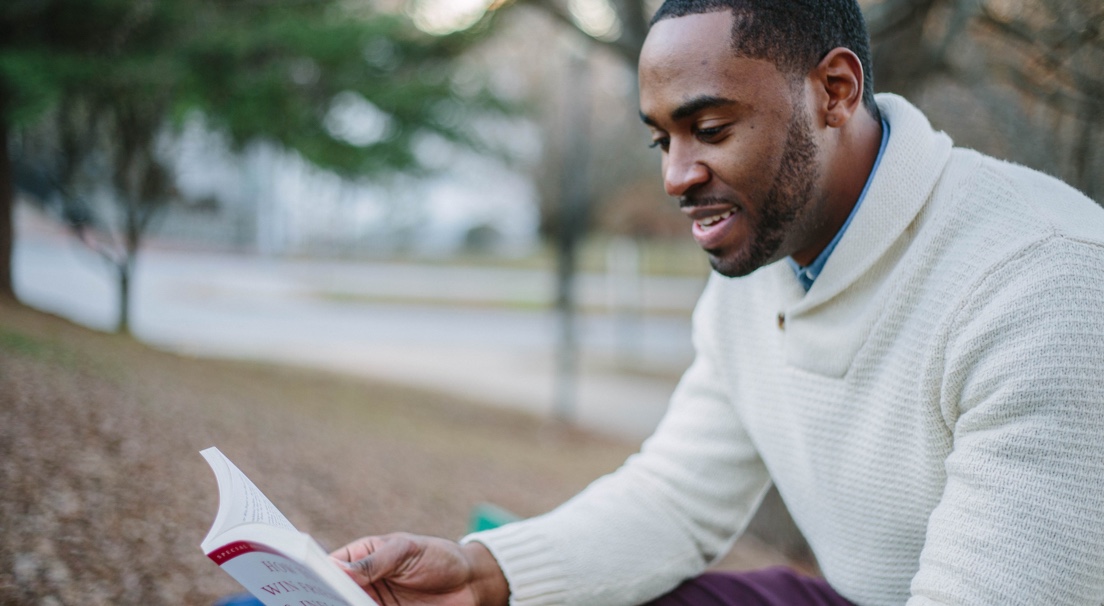 Man reading book in park